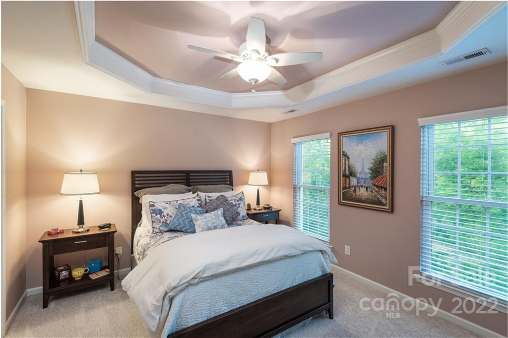 1132 Drayton Court, Unit 130 Fort Mill, SC 29708 - Photo 13 of 24 a bedroom with a bed and a chandelier