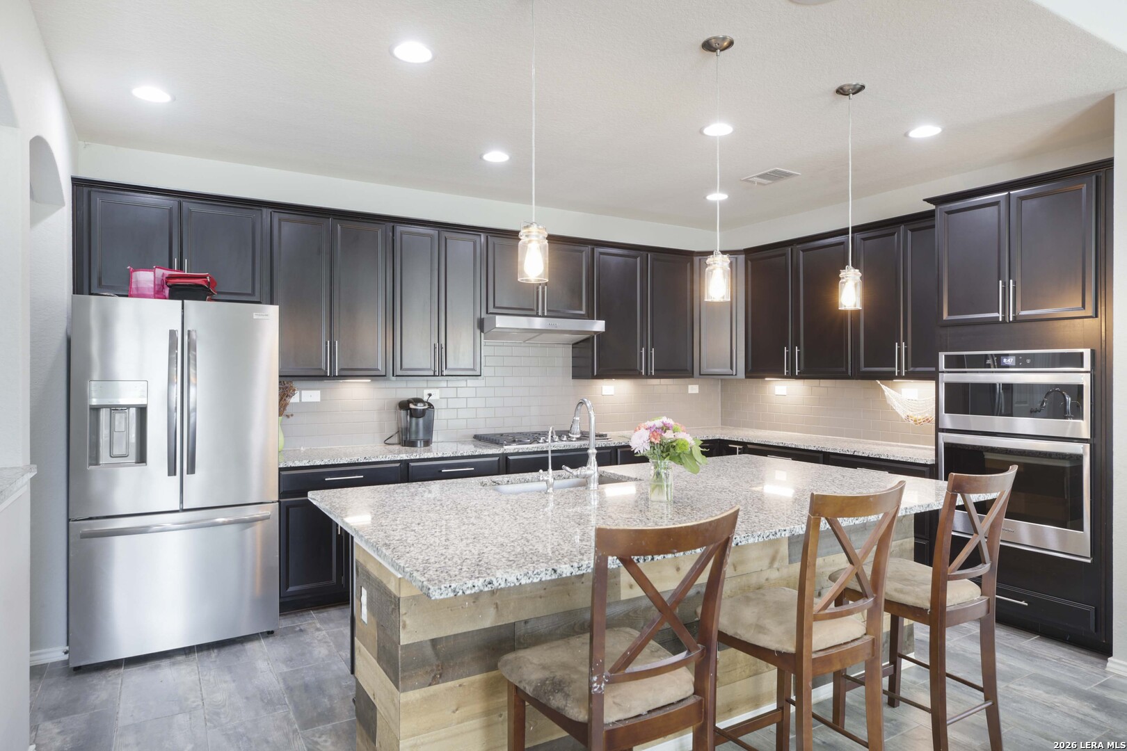 11638 Chalk Stem Schertz, TX 78154 - Photo 9 of 37 a kitchen with granite countertop a refrigerator stove microwave and cabinets