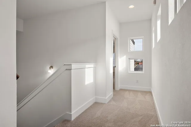 a view of a livingroom with wooden floor and a hallway