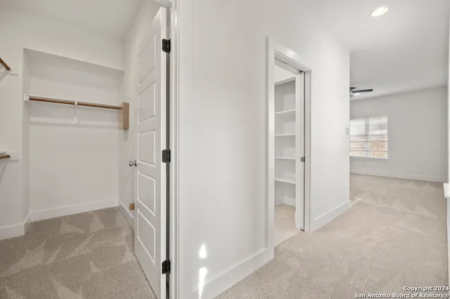 an empty room with a window and a fan