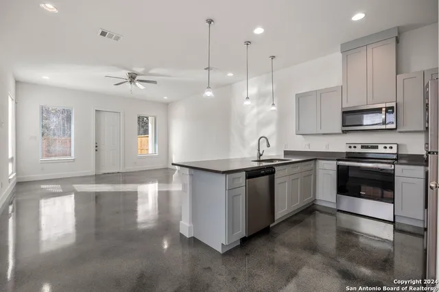 a kitchen with stainless steel appliances granite countertop a stove a sink and a microwave