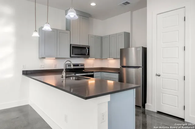 a kitchen with kitchen island a counter top space cabinets and stainless steel appliances