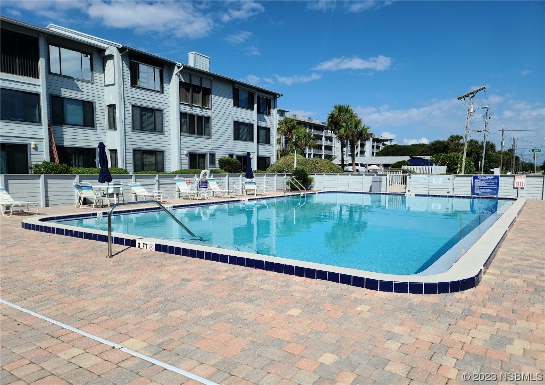 6544 Engram Road, Unit E203 New Smyrna Beach, FL 32169 - Photo 19 of 27 a view of a swimming pool with a lounge chairs