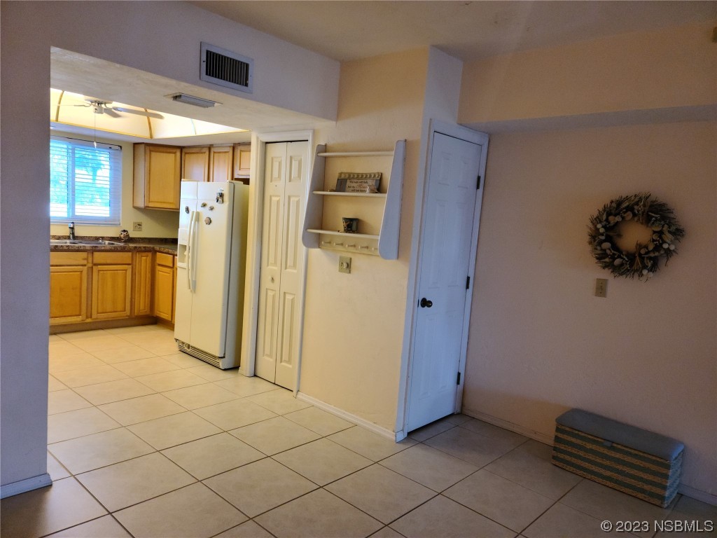 6544 Engram Road, Unit E203 New Smyrna Beach, FL 32169 - Photo 6 of 27 a view of a kitchen with refrigerator and wooden floor