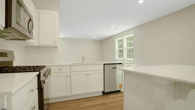 a view of a kitchen with a sink cabinets and wooden floor