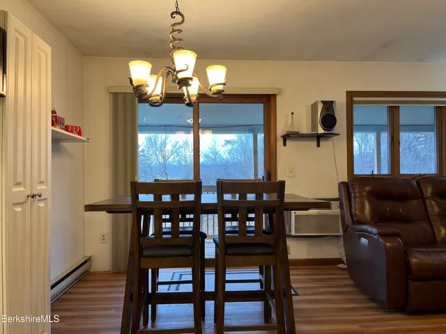 a living room with furniture a flat screen tv and a refrigerator