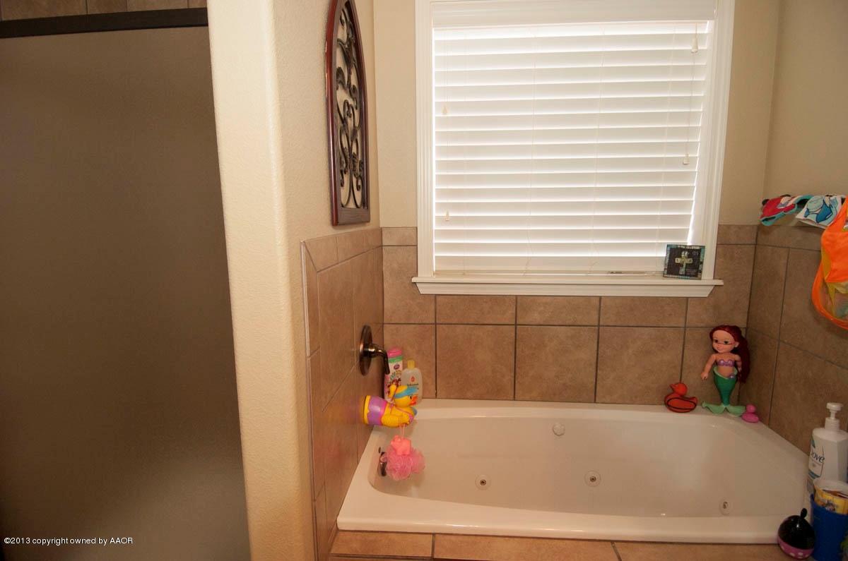 3807 Arden Road Amarillo, TX 79118 - Photo 14 of 26 a bathroom with a tub and a window