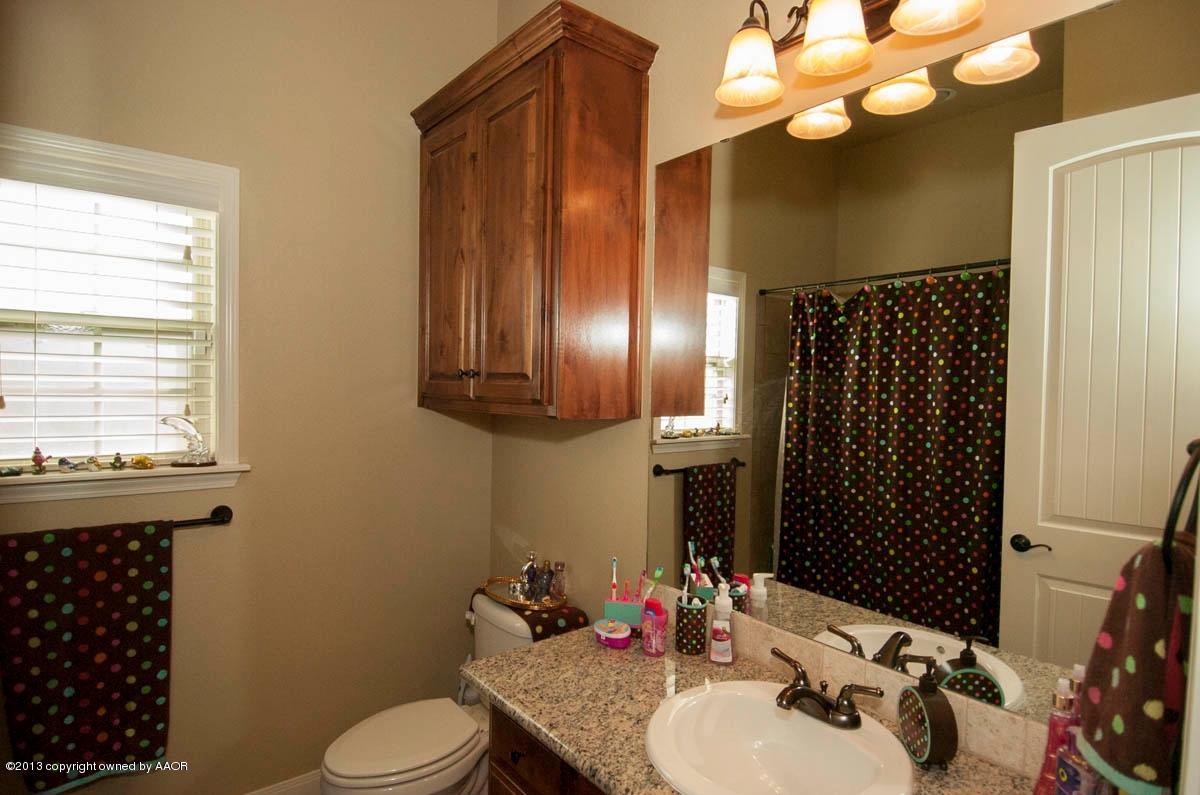 3807 Arden Road Amarillo, TX 79118 - Photo 18 of 26 a bathroom with a sink a toilet a mirror and shower