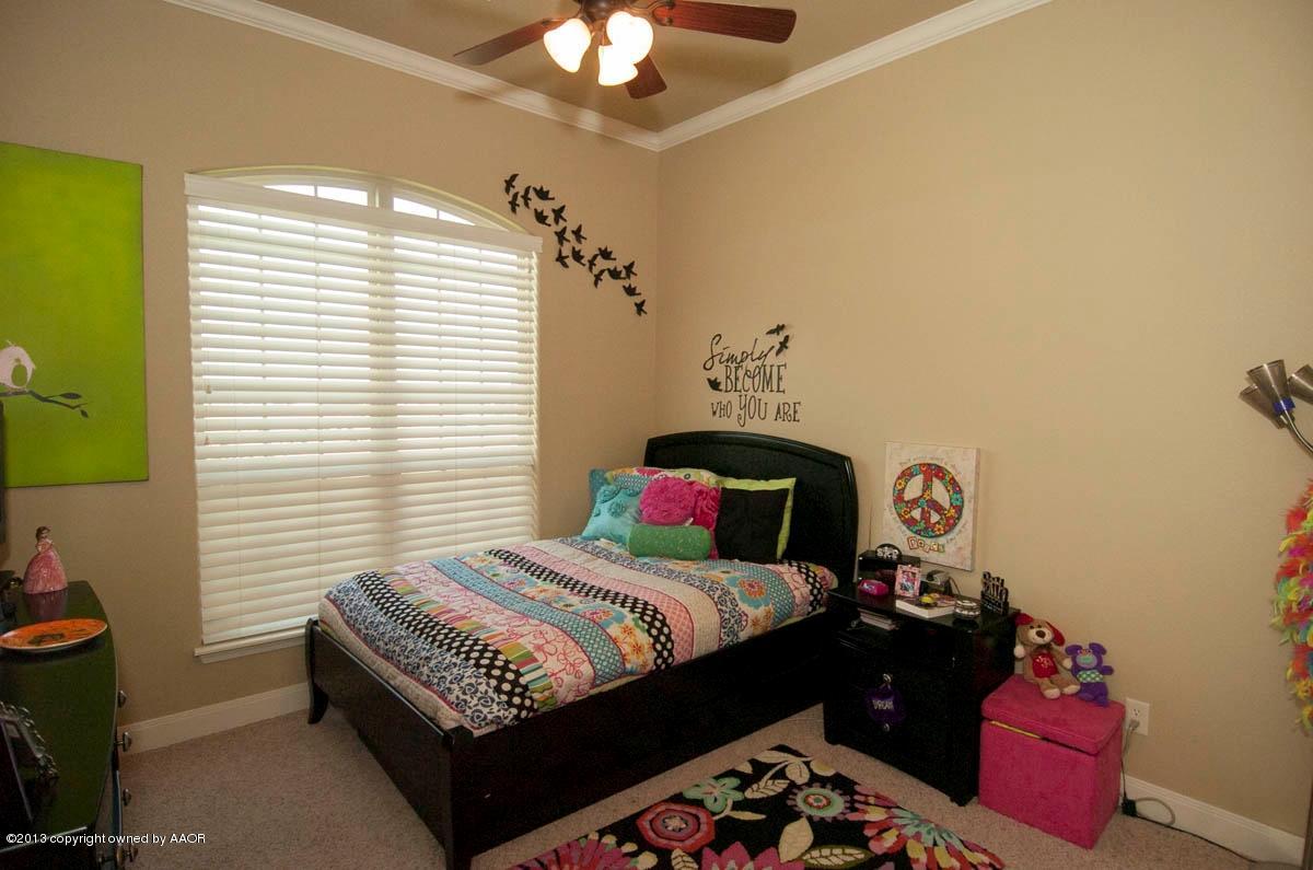 3807 Arden Road Amarillo, TX 79118 - Photo 20 of 26 a bedroom with a bed and a chandelier