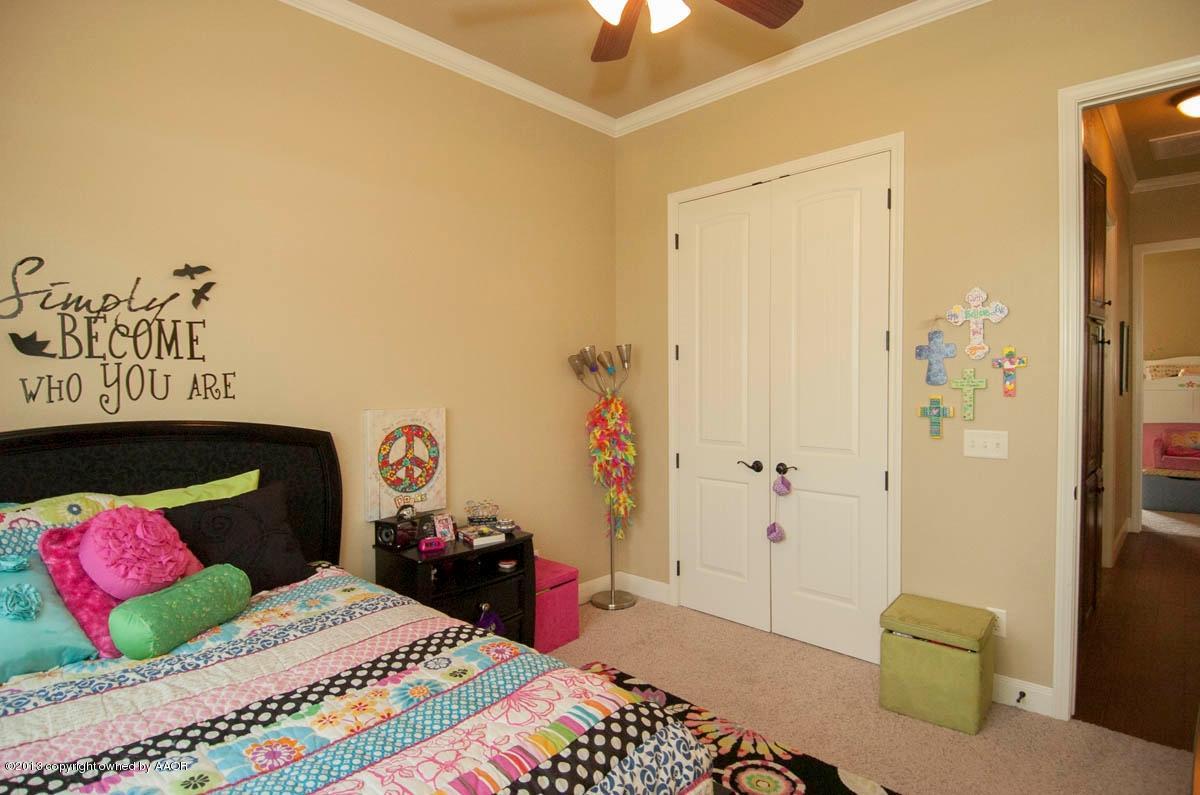 3807 Arden Road Amarillo, TX 79118 - Photo 21 of 26 a bedroom with a bed and a chandelier