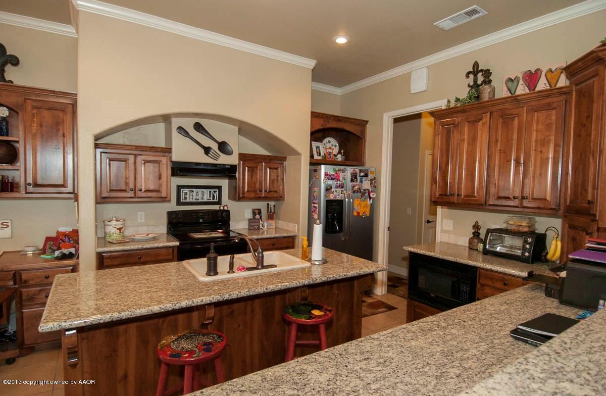 3807 Arden Road Amarillo, TX 79118 - Photo 7 of 26 a kitchen with granite countertop a sink a stove and cabinets