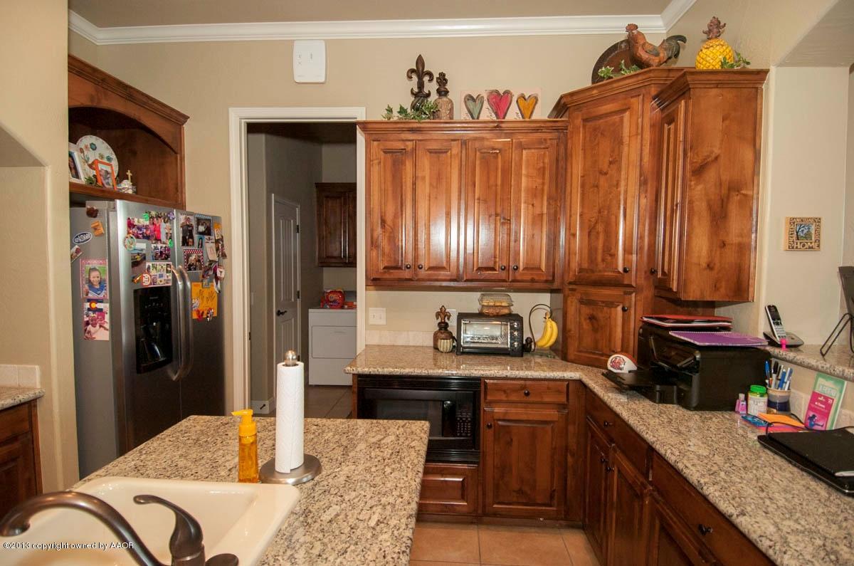 3807 Arden Road Amarillo, TX 79118 - Photo 9 of 26 a kitchen with stainless steel appliances granite countertop a refrigerator a stove and a sink with wooden cabinets
