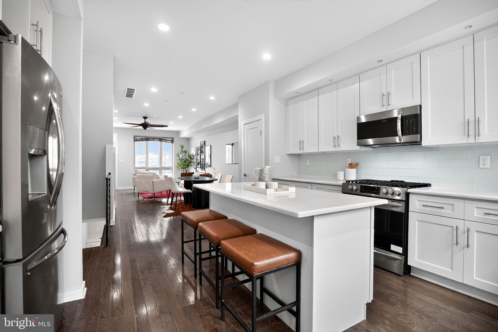 1711 South 20th Street Philadelphia, PA 19145 - Photo 11 of 36 a kitchen with white cabinets and stainless steel appliances