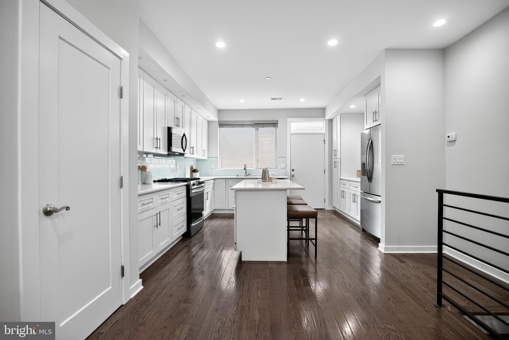 1711 South 20th Street Philadelphia, PA 19145 - Photo 6 of 36 a kitchen with white cabinets and stainless steel appliances