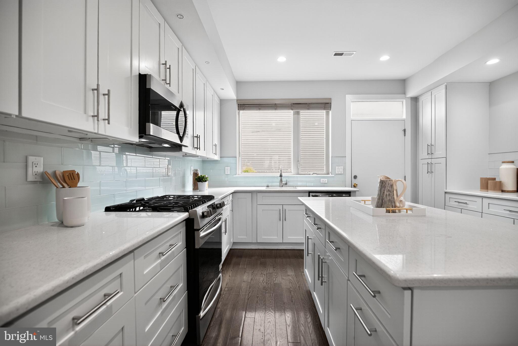 1711 South 20th Street Philadelphia, PA 19145 - Photo 10 of 36 a kitchen with stainless steel appliances granite countertop a sink a stove and a refrigerator