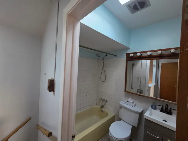a view of an empty room with a ceiling fan and window