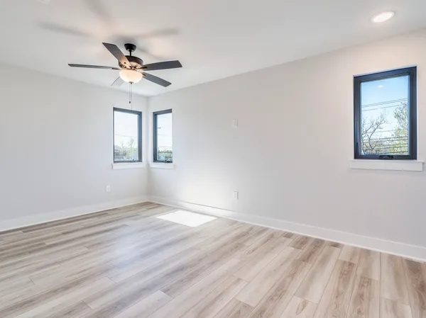 an empty room with a ceiling fan and a window