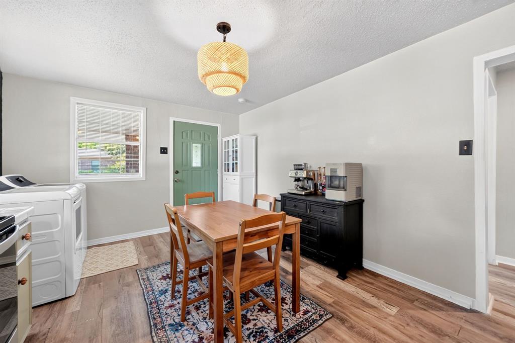 810 Edna Street Athens, TX 75751 - Photo 12 of 28 Dining area featuring wood-finish flooring, a decorative pendant light fixture, and a light green entry door with a window