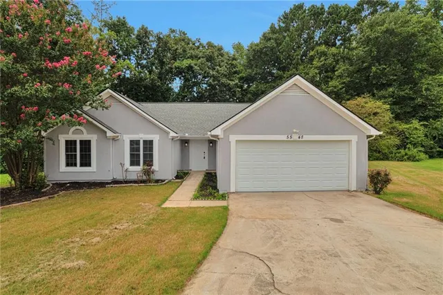 a view of a white house with a yard and large tree
