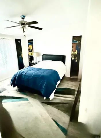 a bedroom with a bed and a ceiling fan
