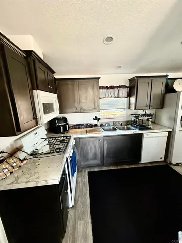 a kitchen with stainless steel appliances granite countertop a sink a stove and a refrigerator