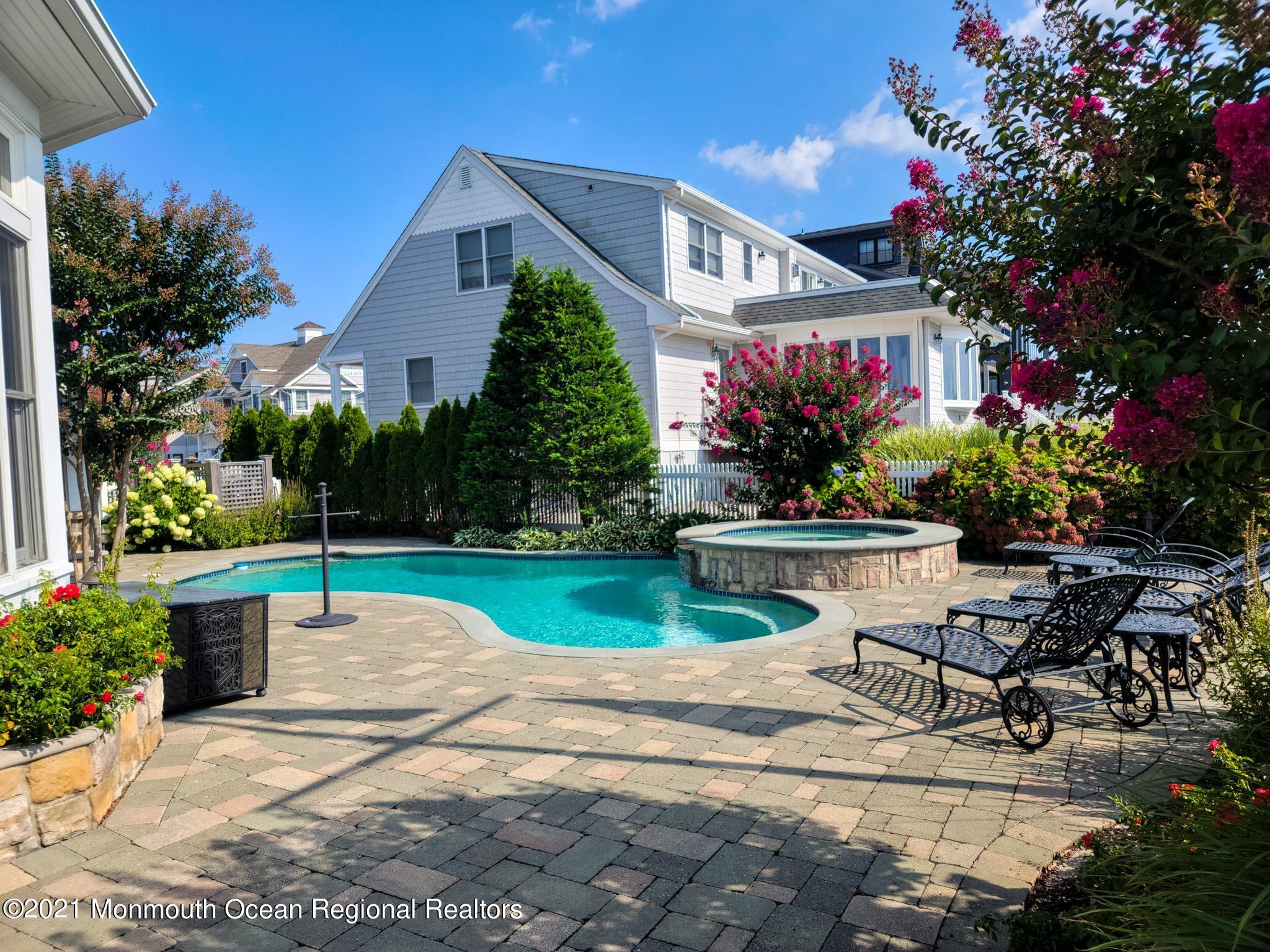 203 Ketch Road Mantoloking, NJ 08738 - Photo 14 of 88 a front view of house and yard with swimming pool and sitting area