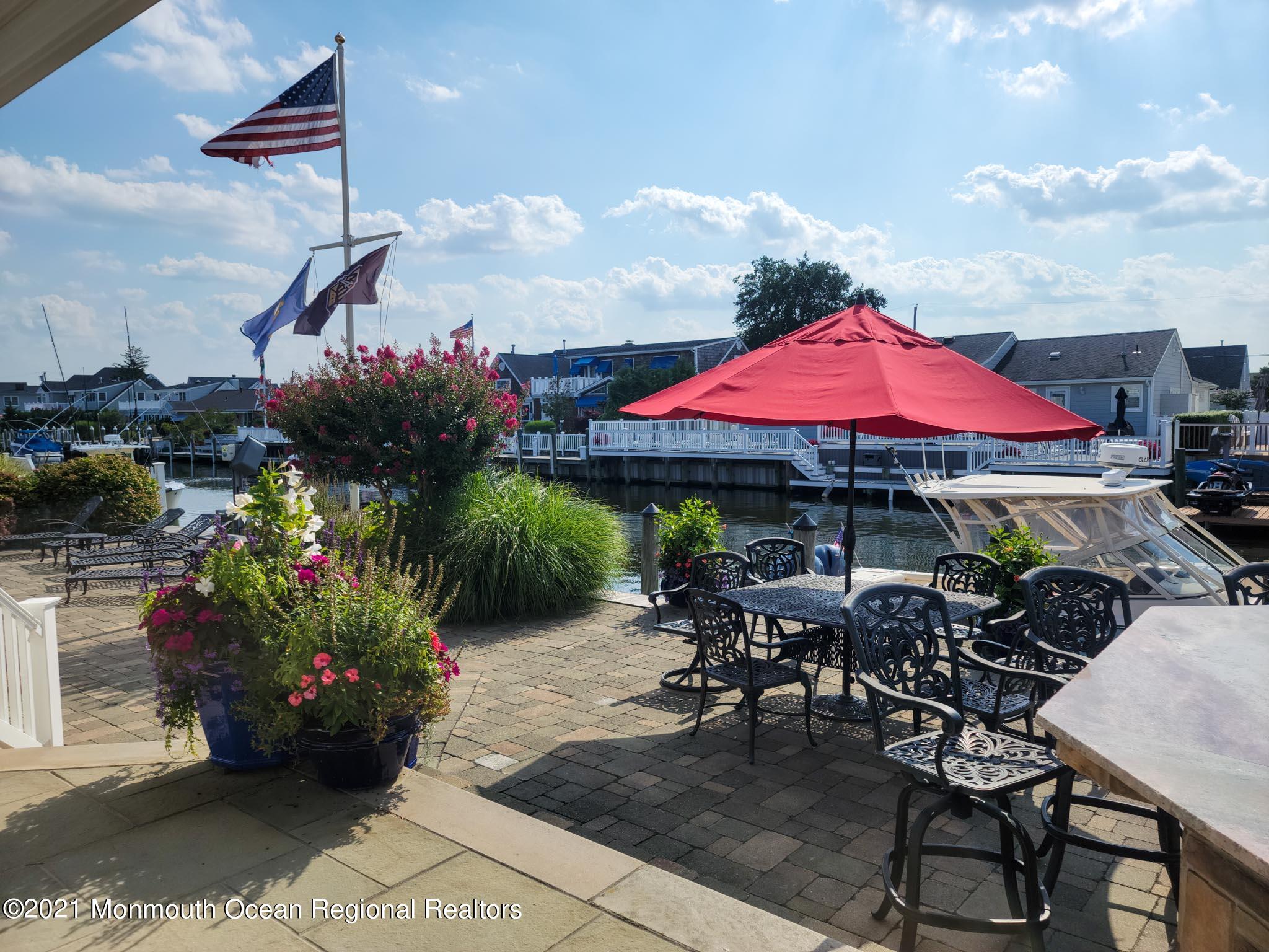 203 Ketch Road Mantoloking, NJ 08738 - Photo 73 of 88 a view of a dining tables and chairs under an umbrella in the patio