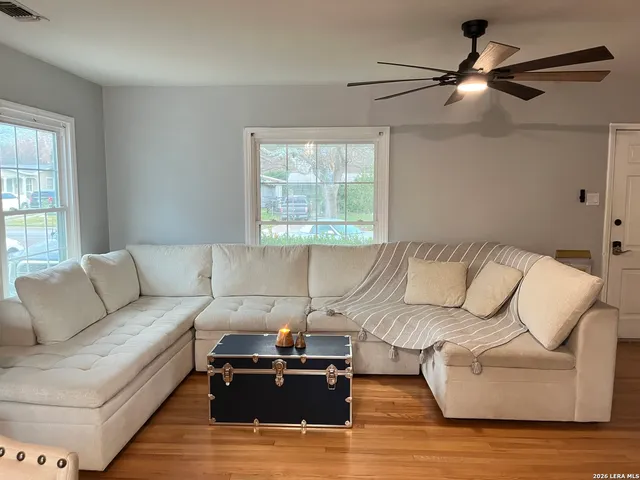 a living room with furniture and a ceiling fan