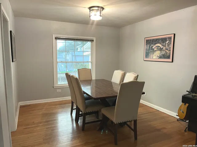 a view of a dining room with furniture a chandelier and wooden floor