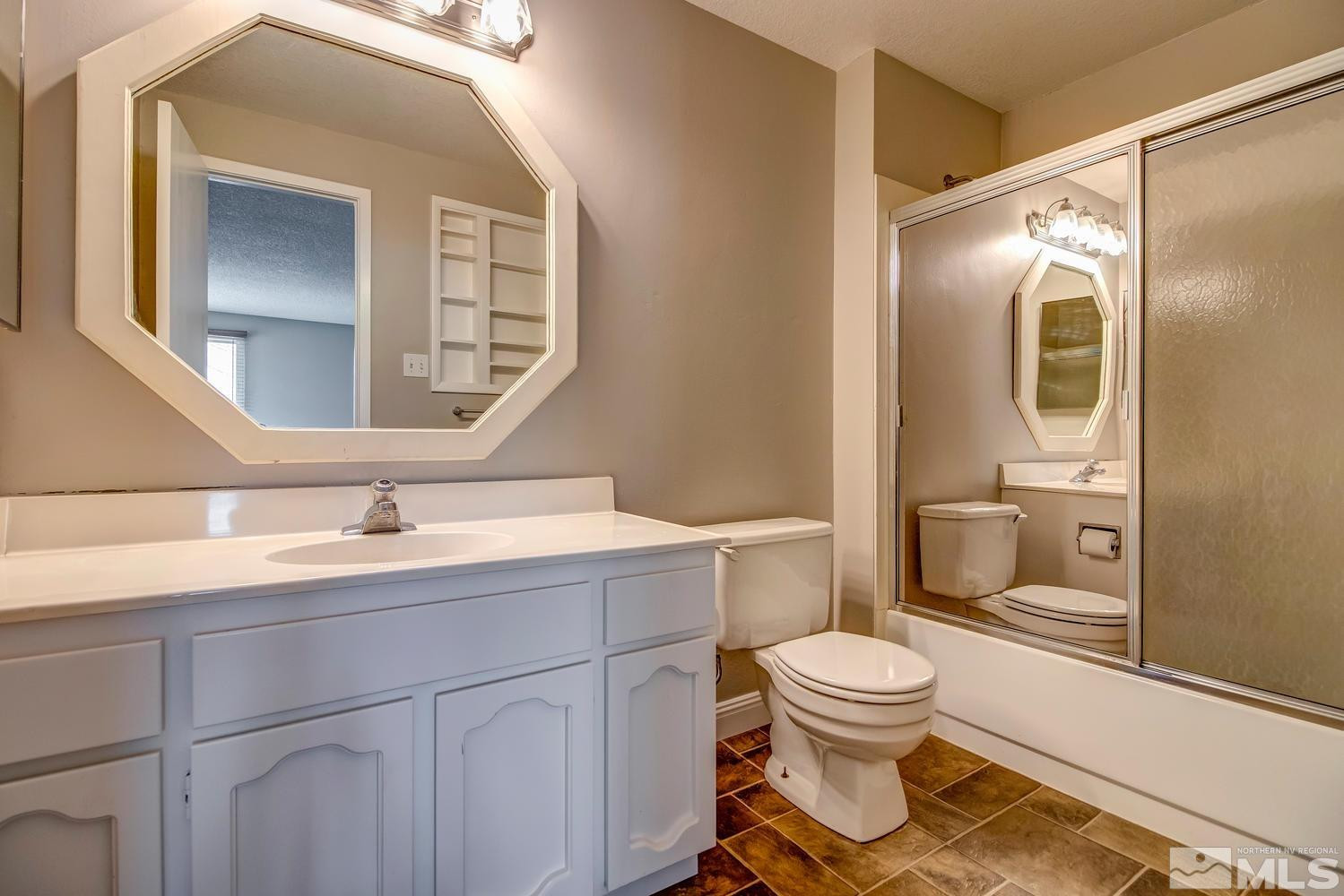 7513 Cumberland Circle Reno, NV 89511 - Photo 16 of 26 a bathroom with a toilet sink a mirror and vanity