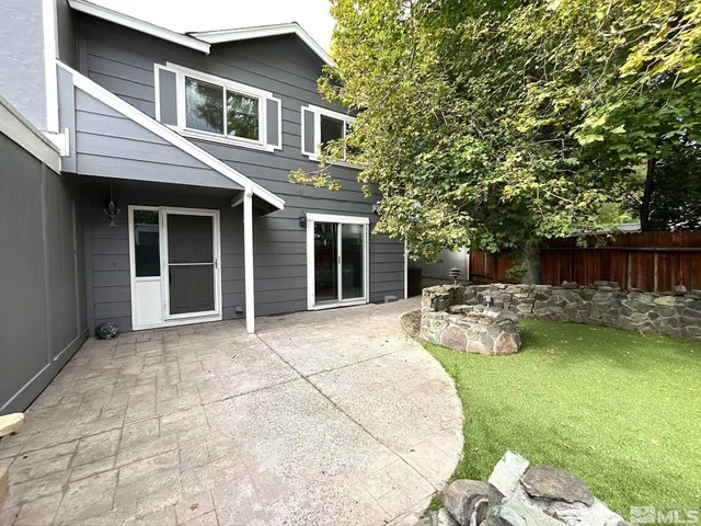 a view of a patio with table and chairs potted plants and large tree