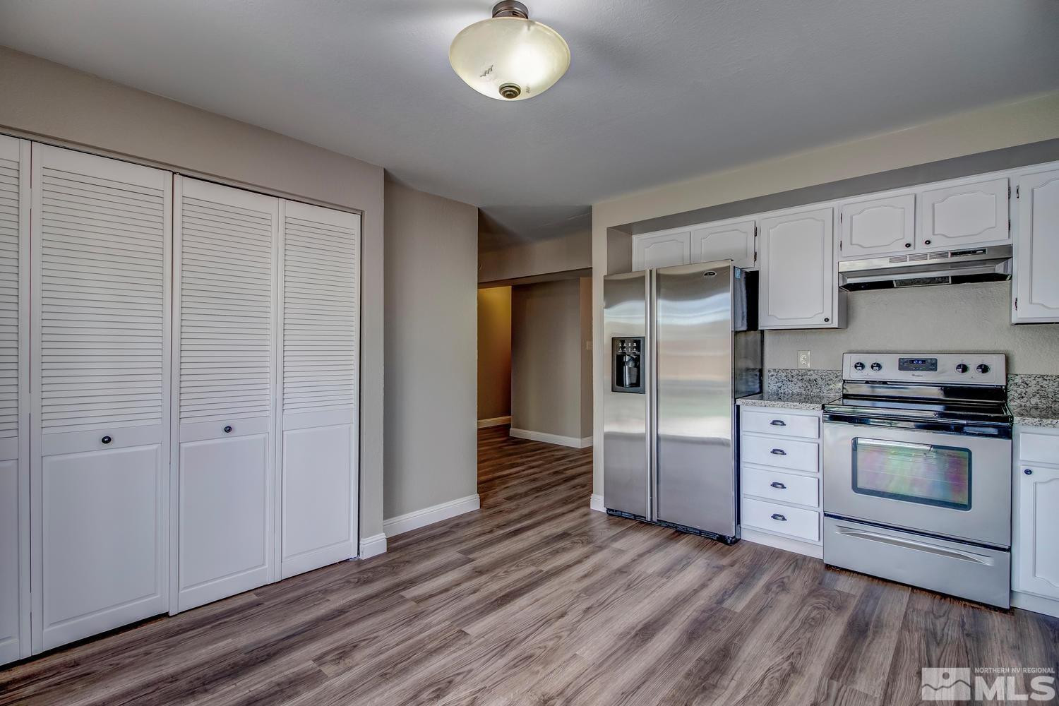 7513 Cumberland Circle Reno, NV 89511 - Photo 4 of 26 a kitchen with stainless steel appliances granite countertop a stove and a refrigerator