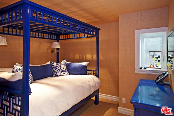 a bed sitting in a bedroom next to a window