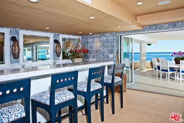 a kitchen with a dining table chairs and cabinets