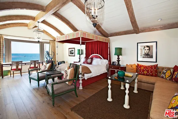 a bedroom with furniture large window and wooden floor