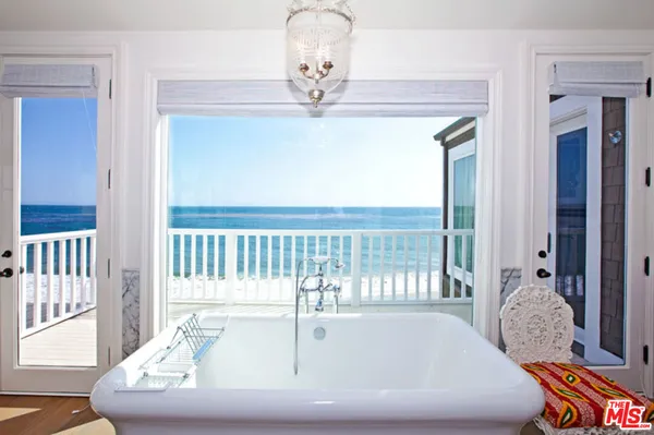 a bathroom with a bathtub and chandelier