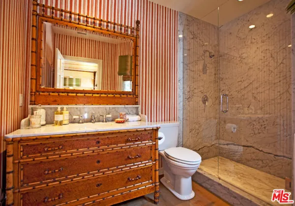 a bathroom with a granite countertop sink toilet a mirror and shower