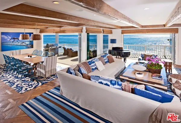 a living room with furniture a flat screen tv and a floor to ceiling window