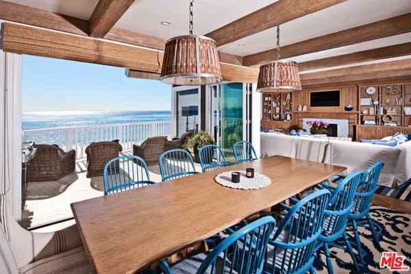 a view of a dining room with furniture a chandelier and wooden floor
