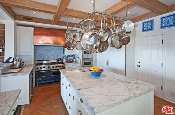 a kitchen with stainless steel appliances granite countertop a sink a stove and a wooden cabinets