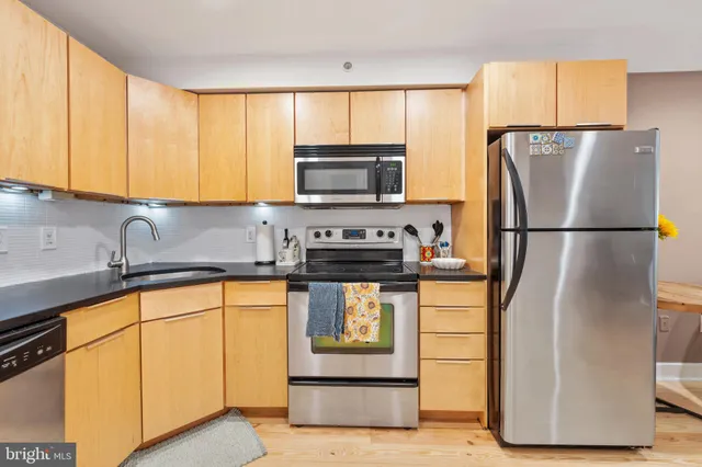 a kitchen with stainless steel appliances granite countertop a refrigerator sink and stove