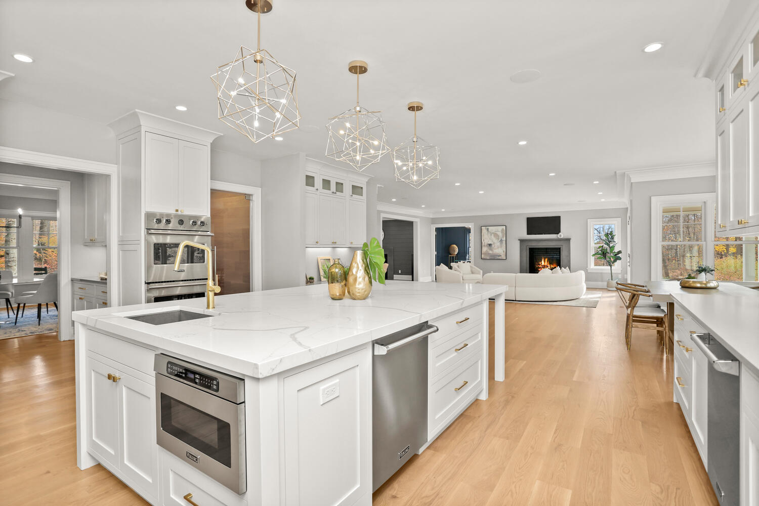 24 Country Club Road New Canaan, CT 06840 - Photo 16 of 43 a large white kitchen with stainless steel appliances granite countertop a stove oven a dining table and chairs with wooden floor