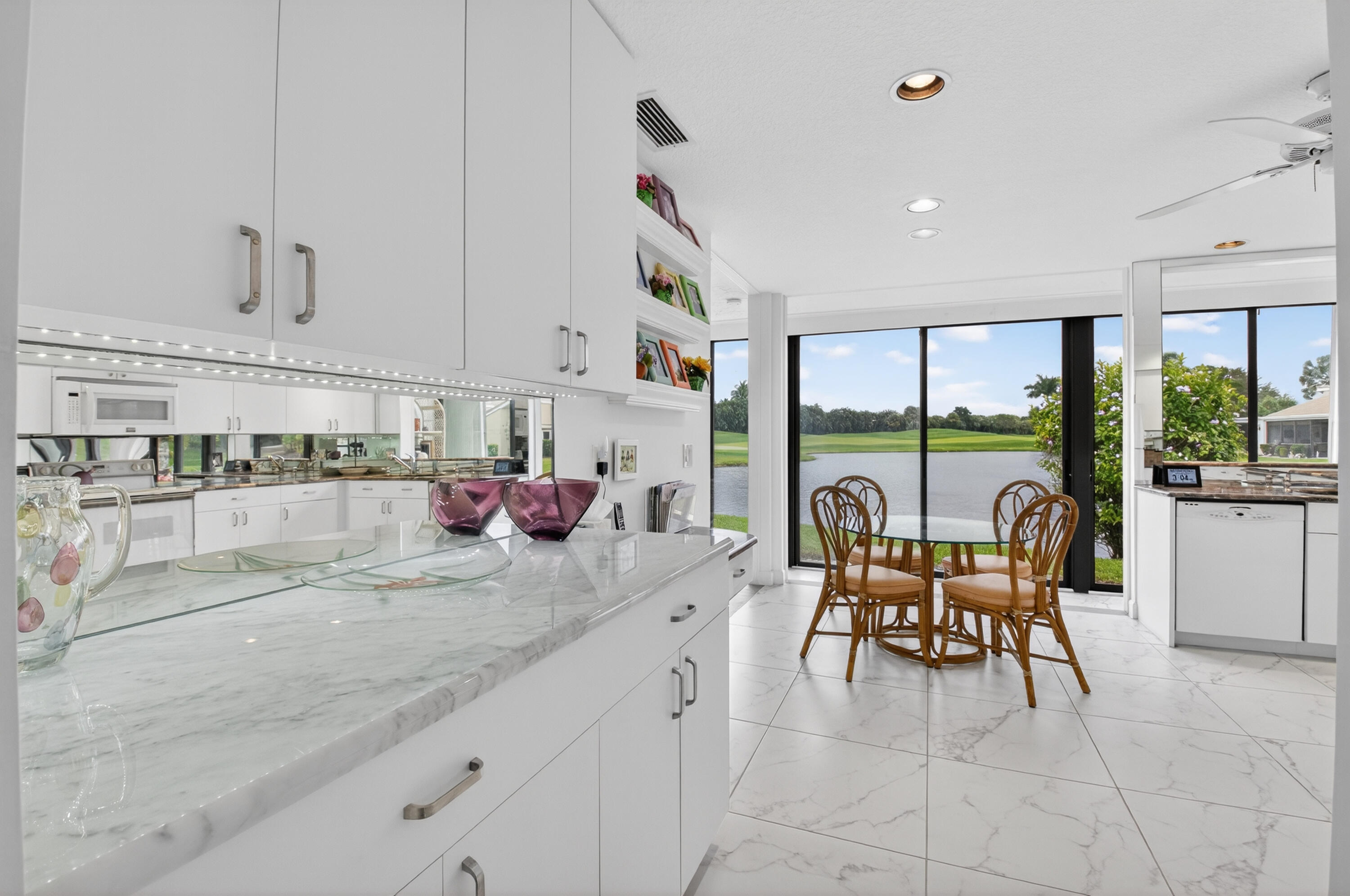 19620 Sawgrass Circle, Unit 2802 Boca Raton, FL 33434 - Photo 12 of 79 a kitchen with stainless steel appliances granite countertop a table chairs and a refrigerator