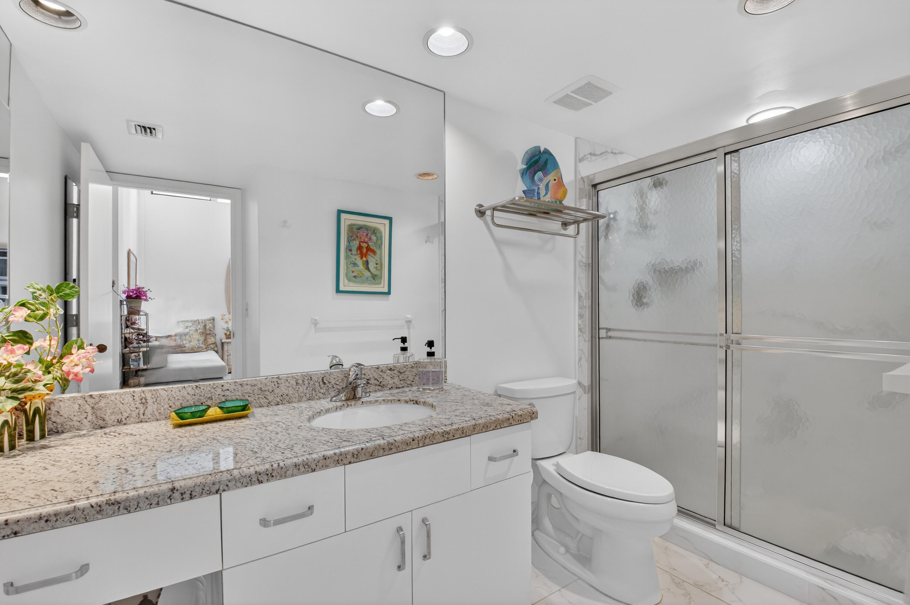 19620 Sawgrass Circle, Unit 2802 Boca Raton, FL 33434 - Photo 26 of 79 a bathroom with a granite countertop sink a toilet a mirror a shower and vanity