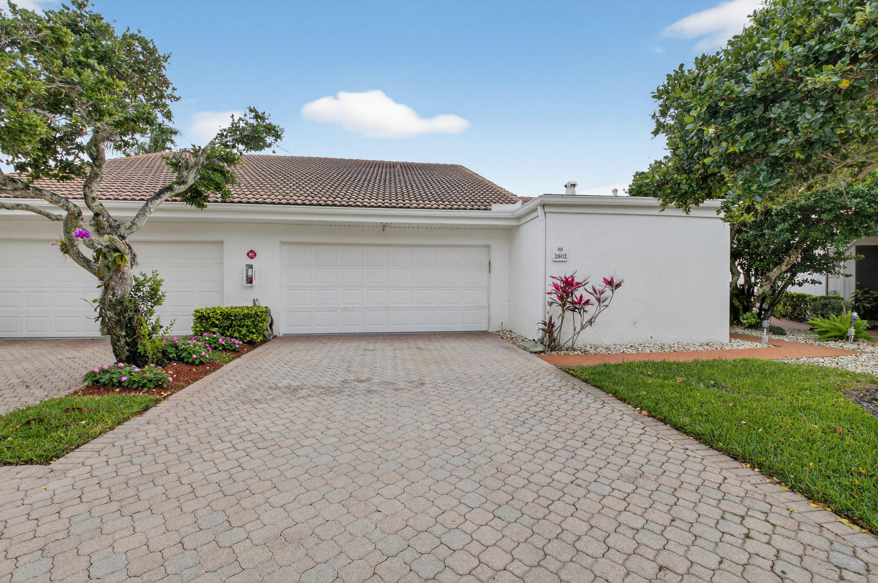 19620 Sawgrass Circle, Unit 2802 Boca Raton, FL 33434 - Photo 39 of 79 a front view of a house with a yard and garage