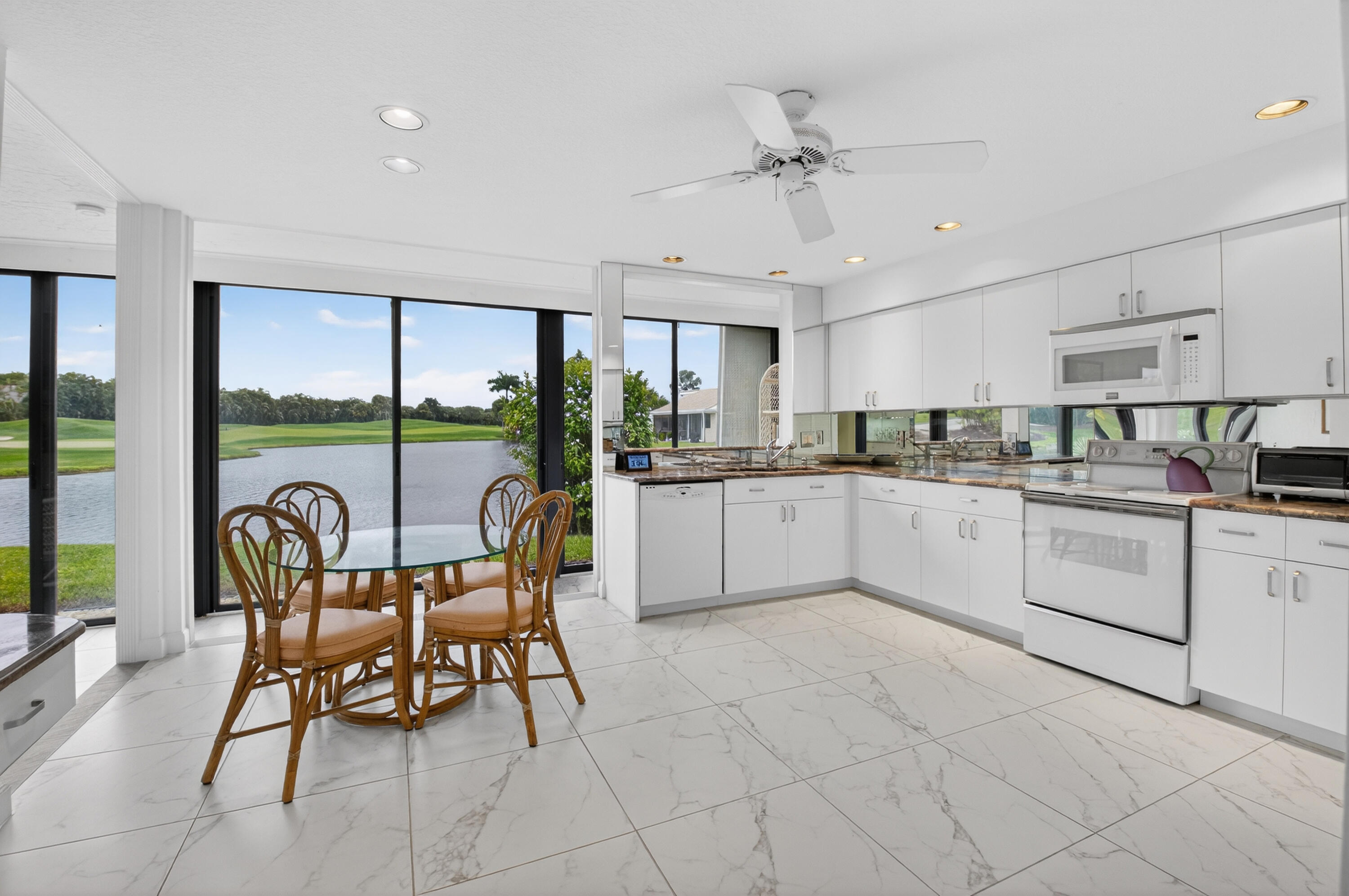 19620 Sawgrass Circle, Unit 2802 Boca Raton, FL 33434 - Photo 10 of 79 a kitchen with stainless steel appliances granite countertop a table chairs sink and cabinets