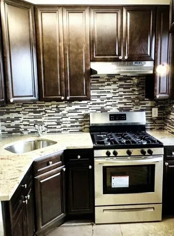 a kitchen with stainless steel appliances granite countertop a stove and a sink