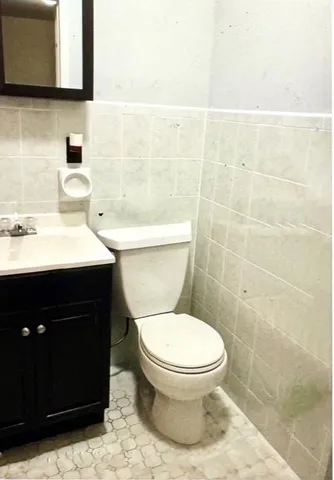 a bathroom with a toilet a sink and mirror