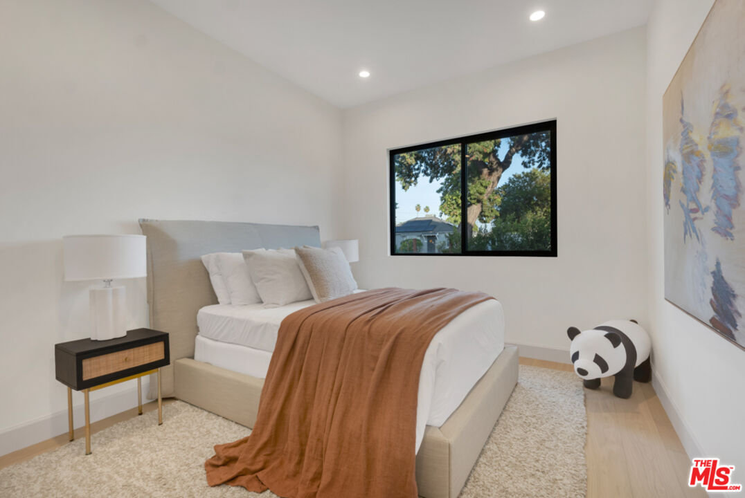 3617 Hillcrest Drive Los Angeles, CA 90016 - Photo 14 of 34 a bed room with a bed and a painting on the wall