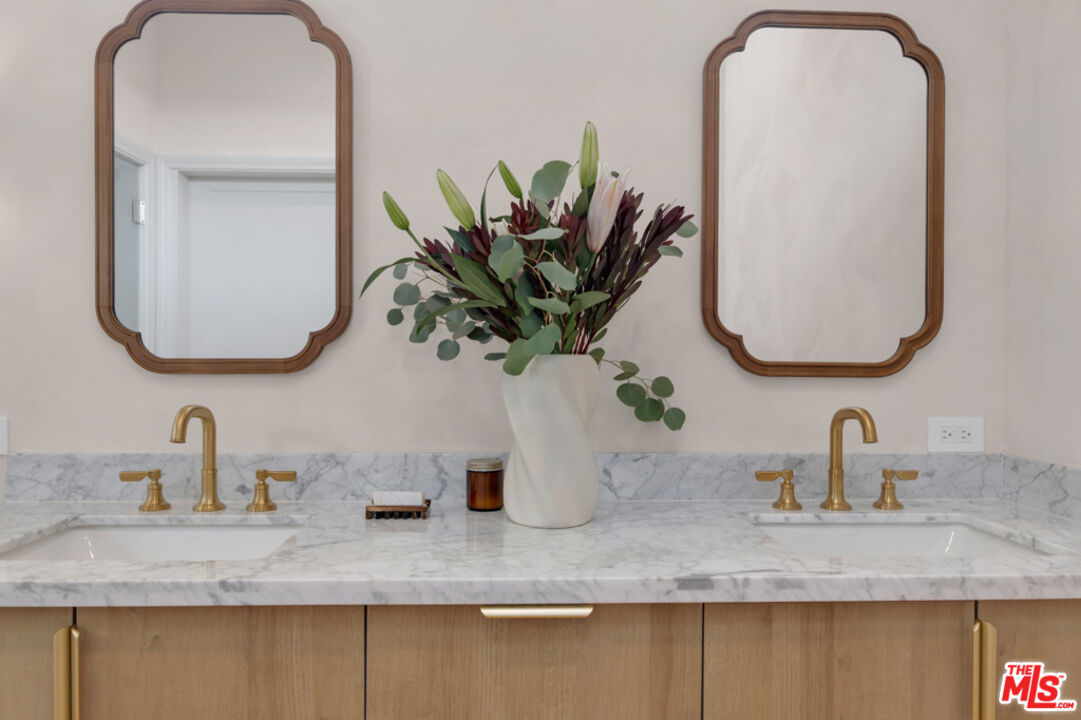 3617 Hillcrest Drive Los Angeles, CA 90016 - Photo 21 of 34 a bathroom with a double vanity sink and a mirror
